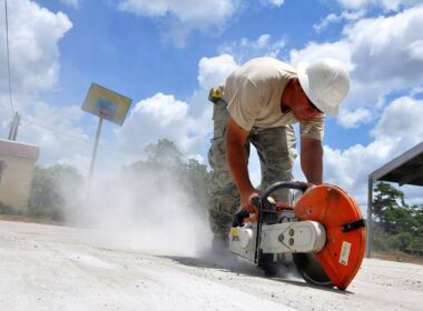 A person grinding concrete without the proper PPE