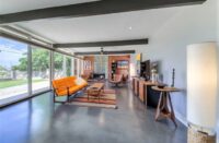 A home with gray concrete floors and an orange couch