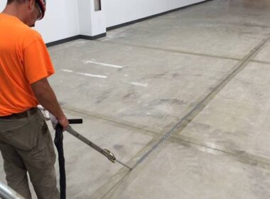 contractor installing joint filler to concrete control joints