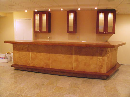 Concrete facade panels enclose the front of this residential bar. When drinkers sit at bar stools, the fronts of bars are often kicked and abused. Concrete panels are very durable.