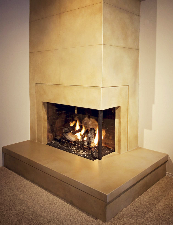 To create the look of this fireplace, Cement Elegance veneered the drywall above and around the fireplace façade with a cementitious microtopping, then cut a score pattern into it to simulate large tiles. The rest of the fireplace was all red brick, over which they installed a microtopping.