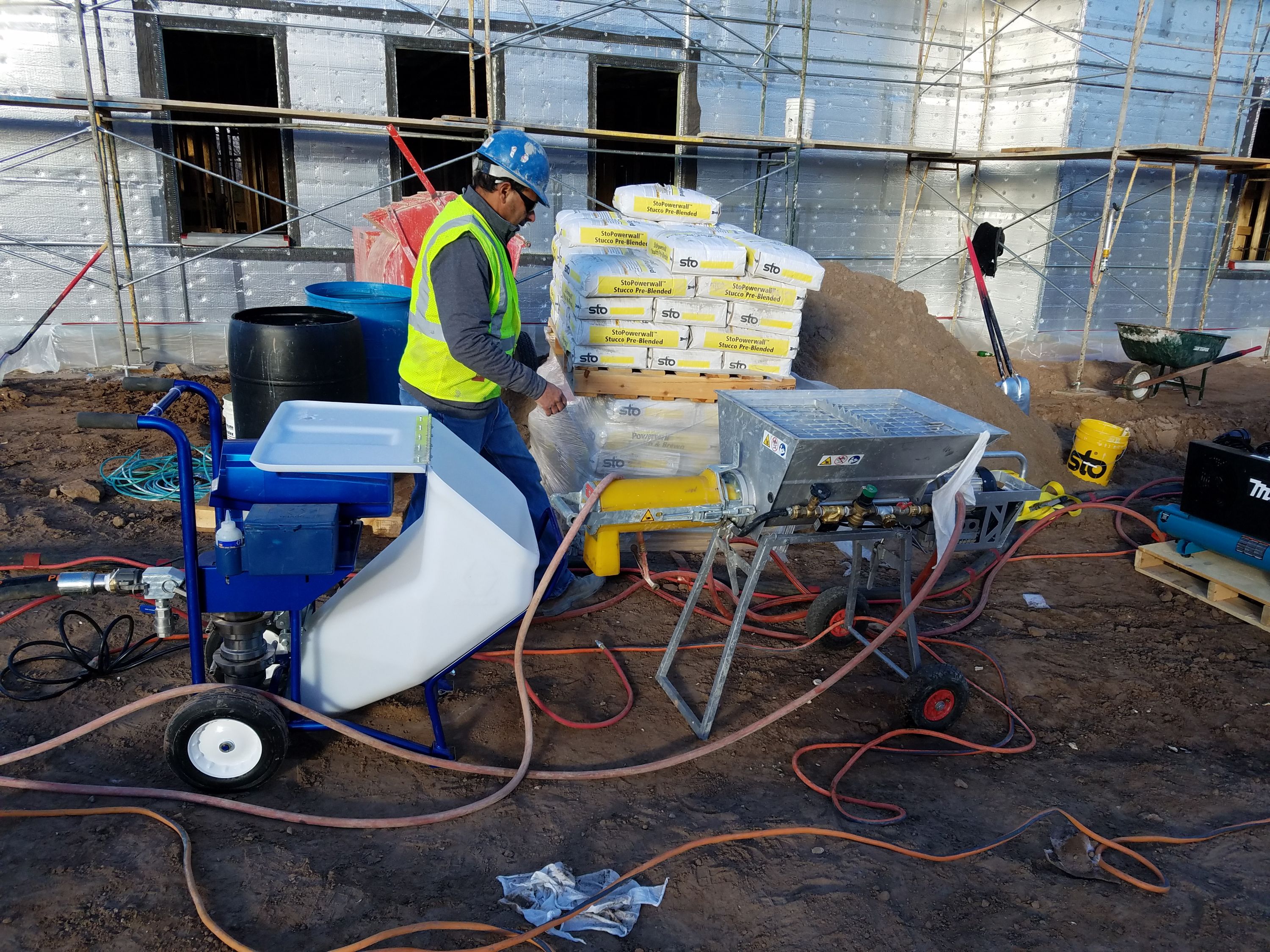 Danny Carillo preparing for applying concrete to the walls using a Graco Sprayer.