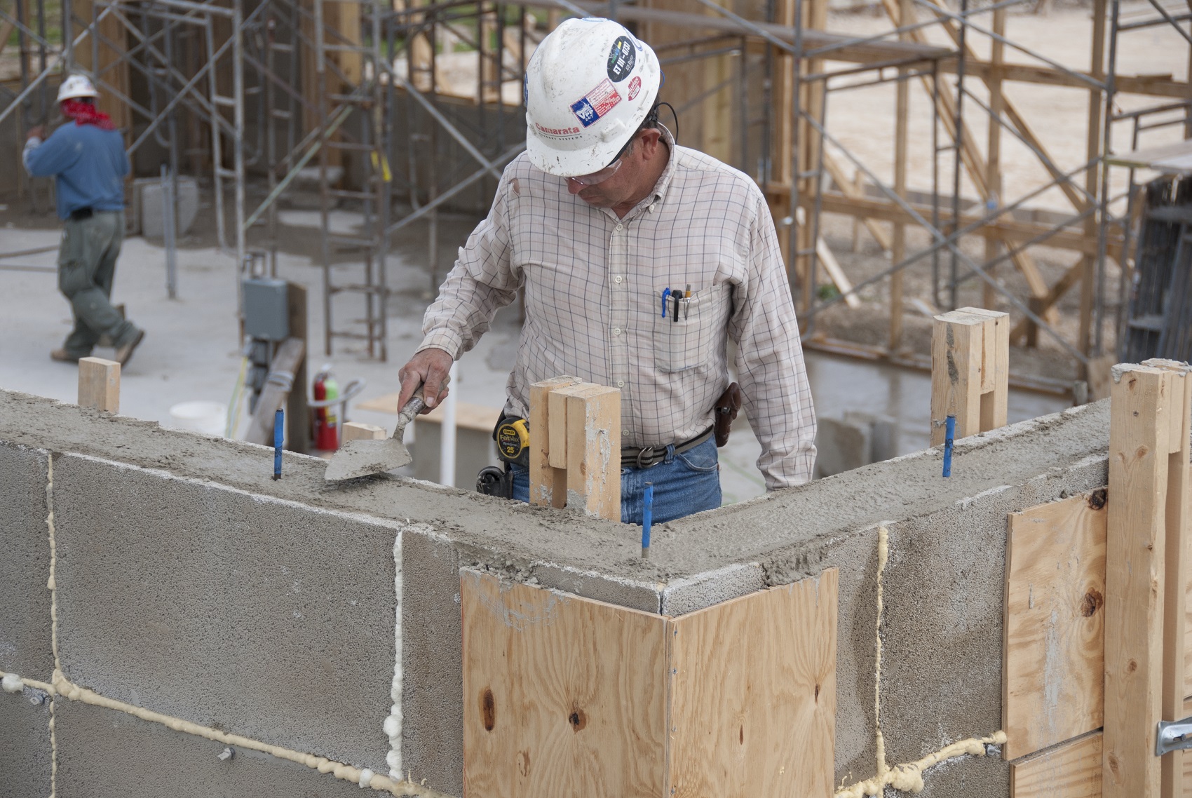 worker leveling out concrete on wall
