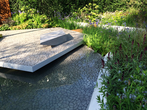 KAZAs contribution to the show garden is the true manifestation of todays unprecedented possibility of extreme bespoke tile design and manufacturing. The seamless cracked earth surface serves as a symbolic yet very real pattern for the waterscape theme of the project.