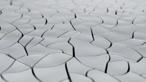 Two different types of larger mosaic-like elements compile the cracked earth pattern. They are made up of 54 different small cracked earth pieces, each individually manufactured, surface-treated and applied onto a carrier layer.