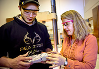 man and woman examining chunck of concrete