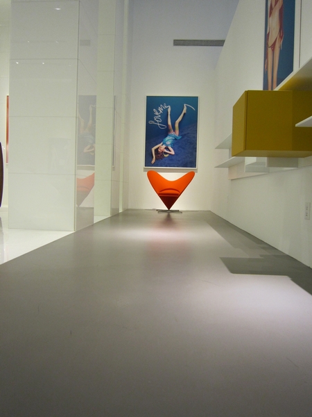 A room in an art museum that is complete with concrete floors.