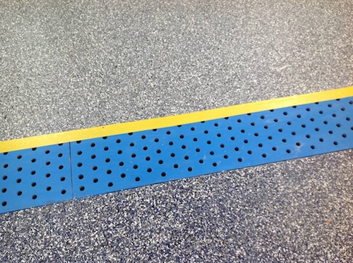 While the Epoxy 200 primer was still wet, four colors of chips - blue, orange, charcoal and green - were broadcast to the point of refusal into the primer, meaning all of the epoxy was completely covered with the flakes and no epoxy was showing. Drain