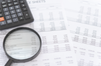 accounting with a calculator and magnifying glass