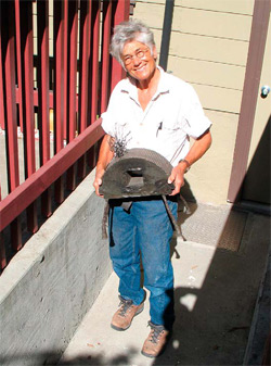 Berkeley, Calif., artist Grayson Malone at the door of her studio, sharing a smile and holding one of her sensory concrete creations