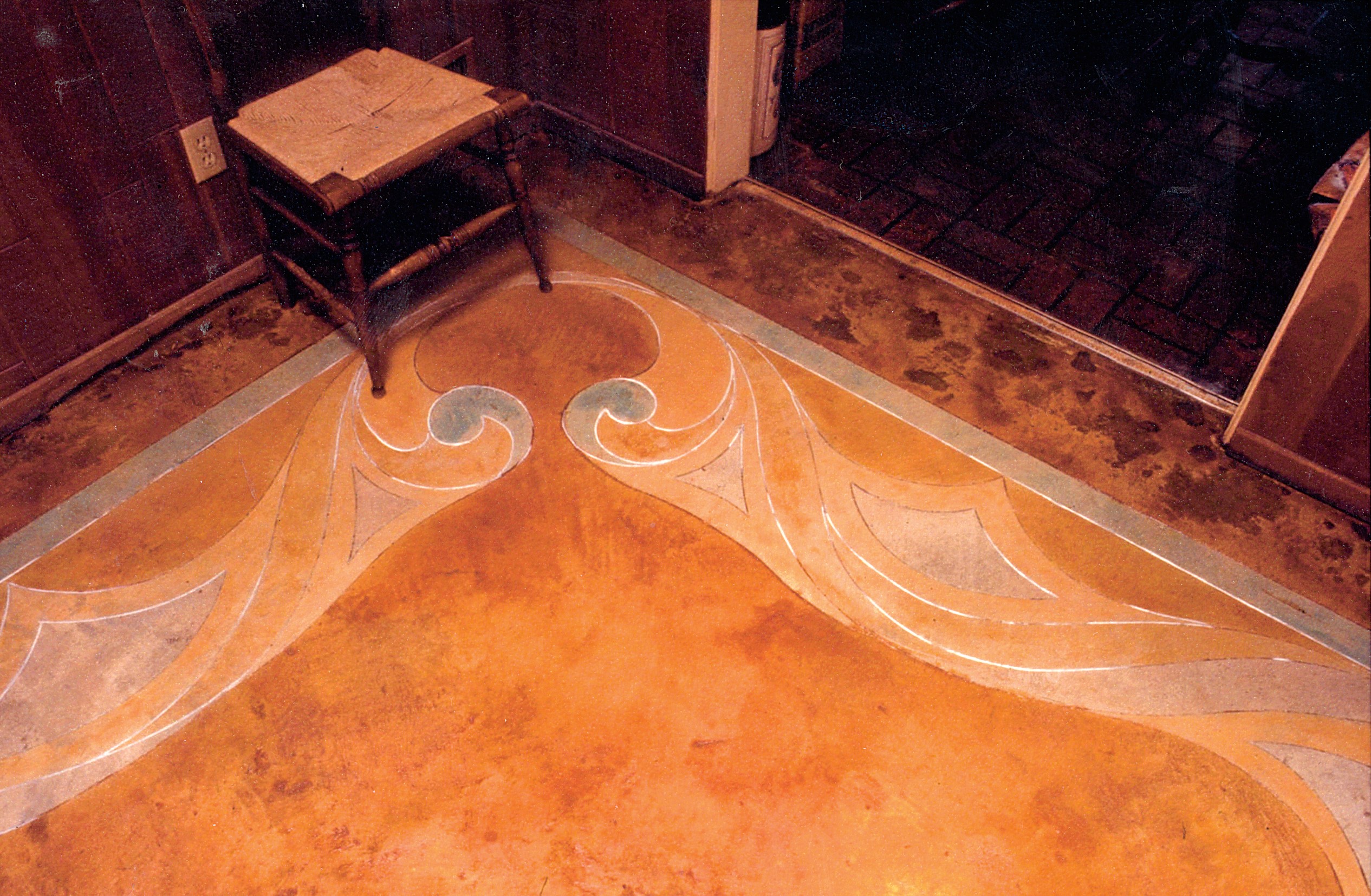 In this living room the concrete was cleared of tack strips and glue and then thoroughly cleaned. The lines and flowing curves were drawn freehand using green chalk.