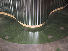 Acid stain on a polished concrete floor has curves in the colors with the help of graphic tape.