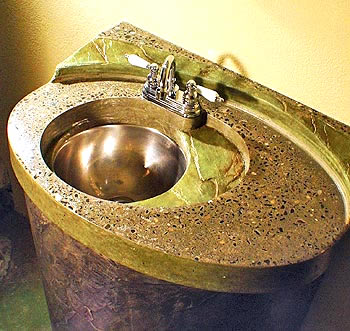 Michael Dahl Winning Entry - Dahls winning sink top has three concentric layers that suggest an egg sliced in half. The primary surface is gray exposed aggregate, while a lower level and most of a back ledge are colored and textured to resemble greenish jade slate. Embedded flecks of stainless steel and hand-blown funnels of glass give the piece a bit of flash
