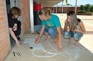 Drawing the pattern for the design to be created on a concrete slab in a public space.