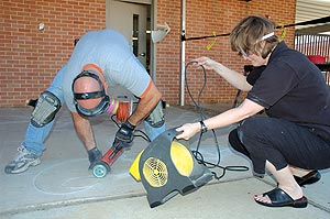 Gerald Taylor cutting the design in concrete for a public art project.