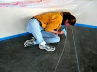 LesCoat - Lead stencil artist Tamara Ryan uses LesCoat to follow a pattern she chalked from an artist's sketch.