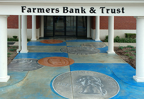 Steven Ochs and Gerald Taylor used concrete stain mimic coin images into the concrete walkway of a Farmers Bank.