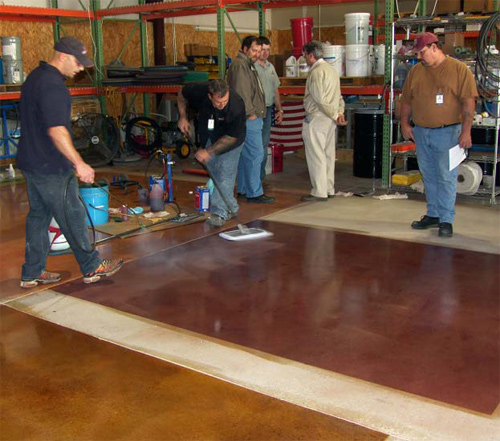 Jason Campbell (with sprayer) and Gary Vidal (with mop) of American Decorative Concrete Supply Co. show observers the correct way to apply ColorJuice to floors. They are spreading ADCSCs Proguard Stain Shield after a ColorJuice application. ADCSC conducts training at its facility every three months.